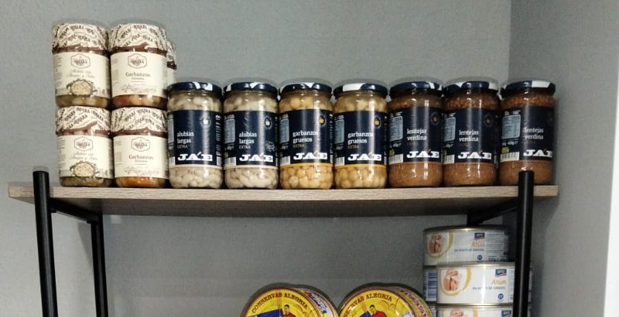 Estantería con legumbres, conservas y miel en la tienda