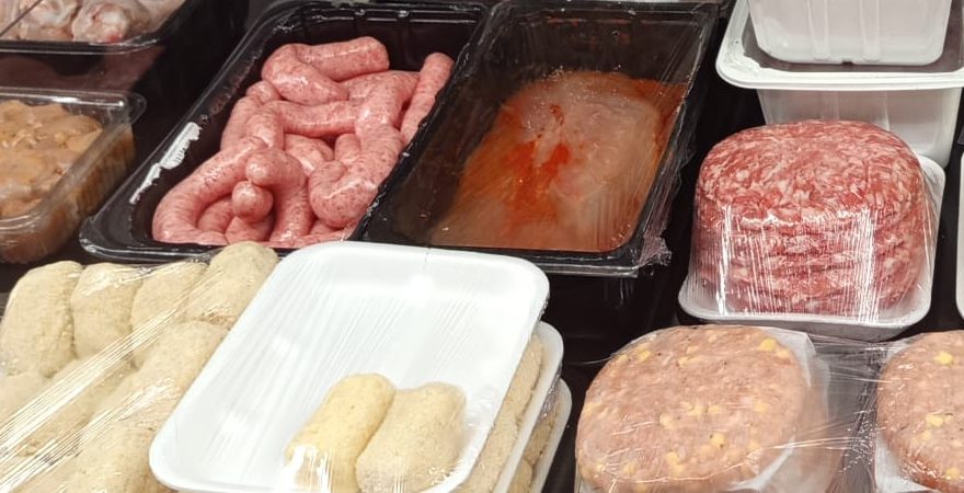 Hamburguesas y salchichas en la vitrina de Pollería Aranda