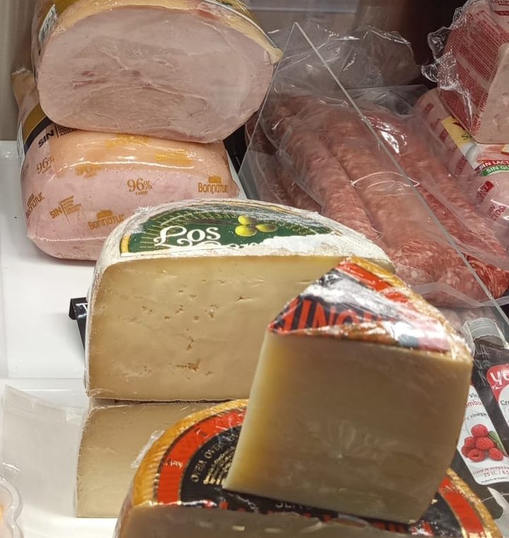 Jamón cocido, salchichón y quesos en el mostrador de charcutería